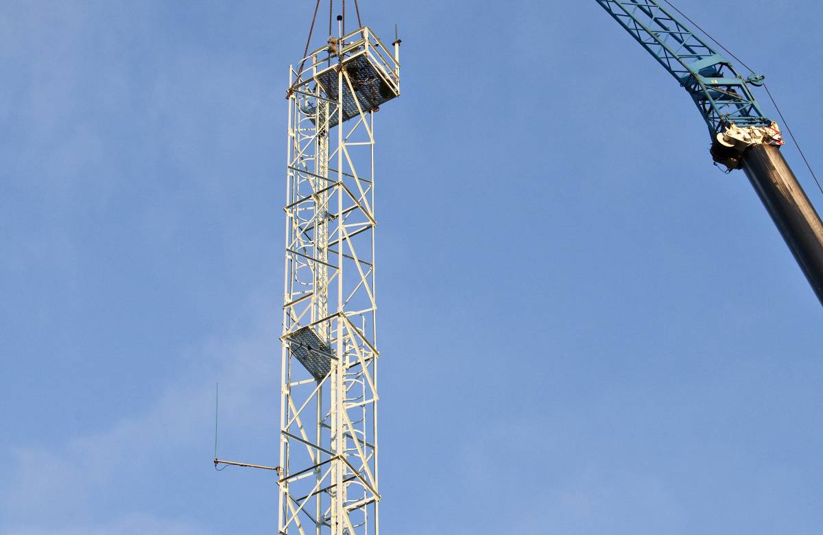 2 Jgc Engineering Engineers working on a cherry picker to aid in the decommissioning of the met tower
