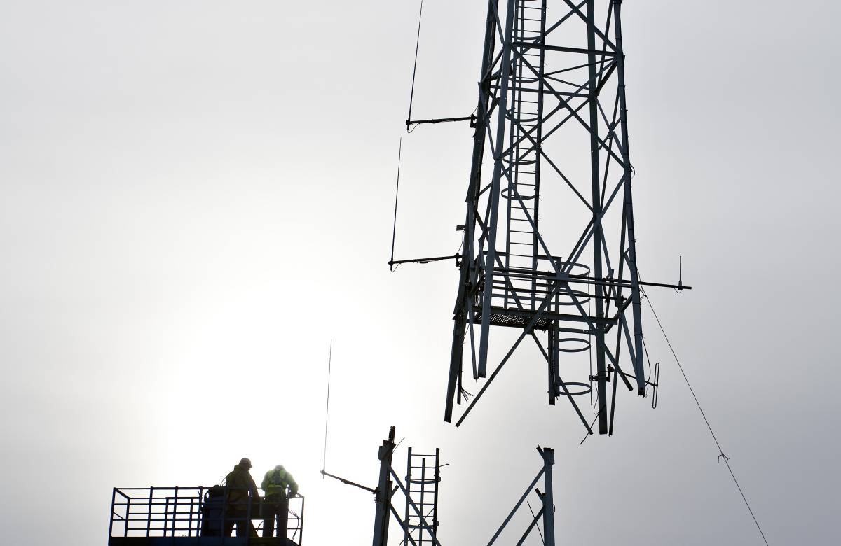 2 Jgc Engineering Engineers working on a cherry picker to aid in the decommissioning of the met tower